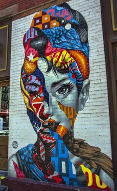 a large mural on the side of a building with a woman's face and many different colors