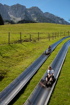 two people riding down a long metal track