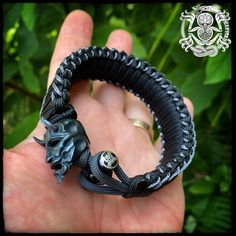 Exquisitely carved brass bead of a Japanese Oni demon in deep blackened brass. .Bracelet in black with gray accents commonly associated with Oni folklore. Other colors available on request. Artisan Hand Wrapped Black Bracelets, Artisan Hand Wrapped Black Bracelet, Black Spiritual Engraved Bracelets, Black Engraved Spiritual Bracelets, Spiritual Black Engraved Bracelets, Artisan Hand-wrapped Black Bracelet, Handmade Symbolic Black Bracelets, Handmade Symbolic Black Beaded Bracelets, Adjustable Black Oxidized Bracelet