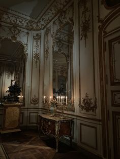 an ornate room with candles lit on the table