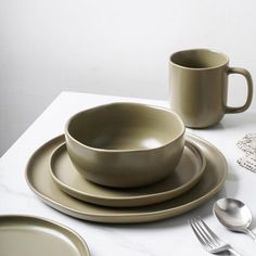 a table set with plates, cups and utensils on top of the table