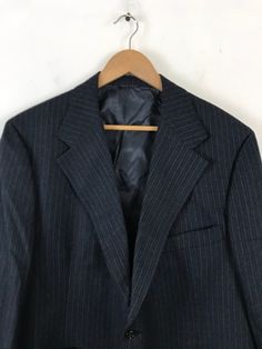 "-Description- >men's dark gray sport coat with light blue pinstripes >two button front >two buttons on the cuffs >three open pockets on the front >vent in the back >partially lined >size 46 >awesome 70s sport coat! >condition: great >color(s): gray, blue >fabric(s): wool >brand: majer >care: dry clean -Measurements- >size: 46 ✩ all measurements are taken with the item laying flat & some sizes are estimates so please check measurements ✩ chest: 46\" Winter Pinstripe Business Suits, Pinstripe Sport Coat With Long Sleeves For Formal Occasions, Pinstripe Suits For Winter Business, Pinstripe Single Breasted Sport Coat For Semi-formal, Semi-formal Pinstripe Sport Coat With Long Sleeves, Semi-formal Pinstripe Single Breasted Sport Coat, Pinstripe Long Sleeve Sport Coat For Semi-formal Occasions, Business Striped Sport Coat With Welt Pockets, Striped Lapel Collar Outerwear For Business