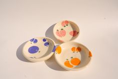 three small bowls with fruit painted on them