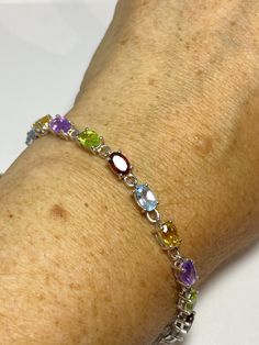 This genuine bright red garnet, citrine, blue topaz, amethysts, and peridot bracelet is very lively and bright. The stones are deep colors natural stones The sterling silver is plated with rhodium to protect the bracelet from tarnish 7.5 in Our jeweler can shorten it for $20 All jewelry is shipped free in the US in a nice gift box. Check out our over a THOUSAND great reviews Engraving is $4 per letter and is not always perfect depending on the piece. It can take a few days if the jeweler is busy Sterling Silver Multicolor Gemstone Bracelets, Sterling Silver Multicolor Gemstone Bracelet, Elegant Multicolor Sterling Silver Bracelet With Stones, Multicolor Sterling Silver Bracelets With Gemstone Accents, Elegant Multicolor Stones Sterling Silver Bracelet, Sterling Silver Multicolor Stone Bracelets, Multicolor Sterling Silver Bracelet With Natural Stones As Gift, Multicolor Gemstone Sterling Silver Bracelets, Multicolor Sterling Silver Bracelet With Natural Stones