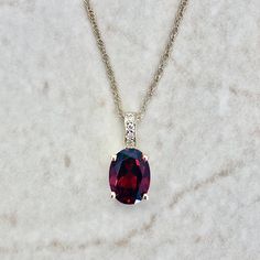 Beautiful and classic 14 karat yellow gold pendant necklace featuring a natural 8x6 mm oval garnet the birthstone for January! The gemstone weighs approximately 1.50 carat. It is accented with 4 diamonds weighing approximately 0.02 carat. The pendant comes with an 18-inch 14 karat yellow gold chain. Birthstone: January. Condition: Brand New. - 14 day return policy, no questions asked. - Free insured shipping in the US. - International shipping available. Note: All items have been appraised and i Yellow Gold Garnet Necklaces With Oval Shape, Yellow Gold Oval Garnet Necklace, Elegant Oval Garnet Necklace, Yellow Gold Oval Necklace With Accent Stones, Oval Yellow Gold Necklace With Accent Stones, Oval Garnet Necklaces For Anniversary, Oval Garnet Necklace For Anniversary, January Birthstone Necklace, Emerald Eternity Band