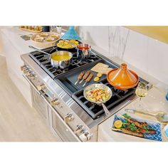 a stove top oven sitting in a kitchen next to a counter with food on it