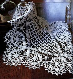 a lace doily on a table next to a bottle of wine