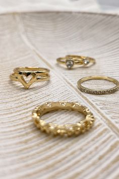 The Veronica Heart Ring Set is a charming collection of seven rings, available in silver or gold and sized at 7. This versatile set includes a variety of designs to suit any style: one ring features an open heart, two rings showcase rhinestone hearts, one plain band offers simplicity, one band is adorned with sparkling rhinestones, one chainlink band adds a unique touch, and one notched band completes the set. Perfect for mixing and matching, the Veronica Heart Ring Set is a delightful way to ac Silver Open Heart Ring For Formal Occasions, Dainty Sterling Silver Open Heart Ring, Stackable Sterling Silver Open Heart Ring, Silver Heart Stackable Adjustable Rings, Silver Heart Ring For Wedding, Open Heart Shape, Clear Purses, Two Rings, Faux Leather Purse, Studded Necklace