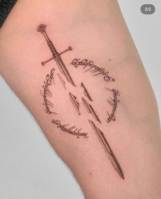 a tattoo on the leg of a woman with two swords and an arrow in it