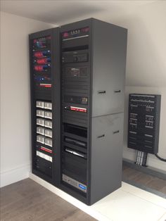 a room with several electronic equipment on the wall and two large cabinets in front of it