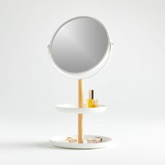 a round mirror sitting on top of a wooden stand