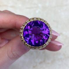 This item has just been reserved by another customer. Please contact us to be notified if it becomes available.  This beautiful Amethyst ring has a round-shaped amethyst with a deep purple color. The amethyst ring weighs approx  13.54 carats and is set in high-quality 18k yellow gold. The Amethyst ring design is enhanced with a row of dazzling diamonds carefully placed on the gold setting.  This vintage ring originating from the 1970s exudes a timeless charm and showcases the stunning allure of Luxury Multi-stone Amethyst Ring For Formal Occasions, Formal Multi-stone Amethyst Ring With Round Cut, Luxury Formal Amethyst Gemstones, Luxury Round Amethyst Ring With Gemstone Accents, Luxury Amethyst Gemstones For Anniversary, Luxury Hallmarked Amethyst Collectible Ring, Luxury Amethyst Gemstones With Prong Setting, Luxury Vvs Clarity Amethyst Ring For Formal Occasions, Luxury Round Amethyst Gemstones