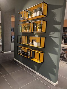 a wall mounted shelf filled with plants on top of a tiled floor next to a dining room table