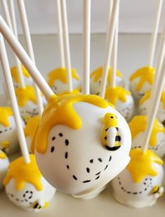 cake pops with yellow and white frosting decorated like a cartoon character are on a table