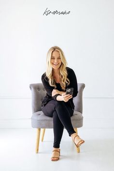 a woman sitting on a chair holding a cell phone