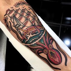 an octopus and ship tattoo on the arm