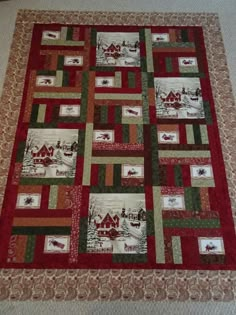 a red and green quilt with houses on it