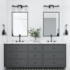 a bathroom with two sinks, mirrors and lights on the wall next to each other