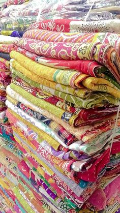 many colorful fabrics are stacked on top of each other