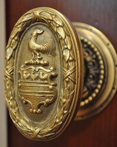 an ornate brass door handle with a coat of arms on the front and back of it