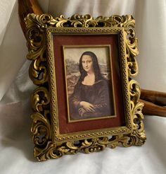 an ornate gold frame holds a portrait of a woman