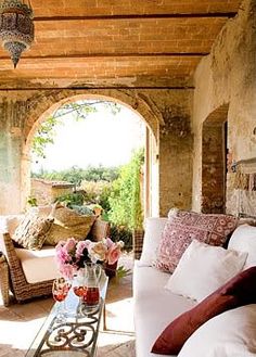 a living room filled with lots of furniture and flowers on top of a coffee table