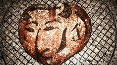 a loaf of bread with the face of jesus on it sitting on a cooling rack