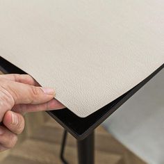 a hand is holding the edge of a table