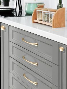 a kitchen with gray cabinets and gold handles