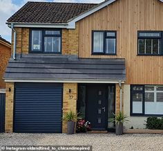 a two story house with garage doors and windows