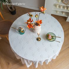 a white table with flowers and plates on it