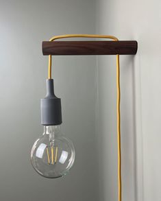 a light that is hanging from a wall with a yellow cord attached to the lamp