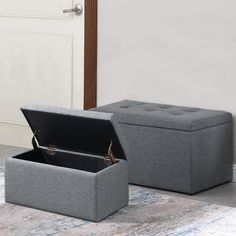 two grey storage boxes sitting on top of a rug