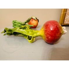 an apple, broccoli and other vegetables on a table