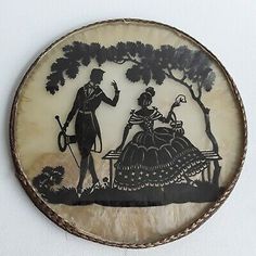 a black and white plate with an image of a man and woman sitting on a bench