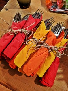 there are forks and napkins tied together on the table with other utensils