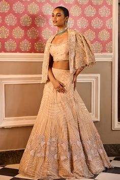 Champagne attached cancan lehenga featuring hand embroidered glass bead, sequin and golden wire detailing all over. Paired with an embroidered, padded blouse. Comes with an embroidered, scallop sleeve hem jacket. - Aza Fashions Embroidered Choli With Cape Sleeves For Reception, Fitted Choli With Resham Embroidery And Cape Sleeves, Fitted Lehenga With Resham Embroidery And Cape Sleeves, Embroidered Lehenga With Cape Sleeves For Diwali, Embroidered Lehenga With Cape Sleeves For Reception, Diwali Embroidered Lehenga With Cape Sleeves, Fitted Lehenga With Zari Work And Cape Sleeves, Reception Sharara With Intricate Embroidery And Cape Sleeves, Embroidered Choli With Cape Sleeves For Wedding