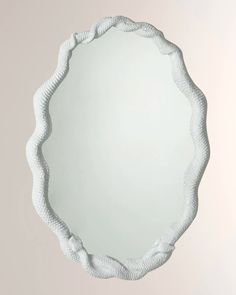 a white circular mirror hanging on the wall