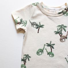 Discover the perfect blend of style, comfort, and sustainability with our Cedar Tees. Made from organic cotton, these tees are designed to provide a soft and breathable experience for your little ones. Available in sizes from Newborn (NB) to 9/10, our Cedar Tees are the ideal choice for parents who value both quality and eco-friendliness. Key Features: 95% Organic Cotton 5% Spandex: Crafted from premium organic cotton, our tees are gentle on sensitive skin and free from harmful chemicals. Comfor Casual Cotton T-shirt With Dinosaur Print, Organic Cotton Graphic Print Tops For Playtime, Relaxed Fit Organic Cotton Tops For Playtime, Playful Organic Cotton T-shirt For Playtime, Organic Cotton Crew Neck Top For Playtime, Casual Organic Cotton Crew Neck Top, Printed Cotton T-shirt For Playtime, Green Cotton Dinosaur Print Tops, Green Cotton Tops With Dinosaur Print