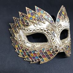 Maschera veneziana fatta a mano in carta pesta e decorata con colori acrilici, foglio d'oro e glitter. La forma di questa mashcera è particolarmente originale, così come la sua decorazione, anch'essa realizzata interamente a mano. Tutte le nostre maschere sono realizzate a mano in carta pesta, a Venezia. I nostri decoratori usano le tecniche tipiche della tradizione veneziana: lo stucco, la tecnica dello screpolato, colori acrilici, macramè, passamaneria, glitter, foglia d'oro e d'argento. Quest Multicolor Masks And Prosthetics For Mardi Gras Carnival, Multicolor Masquerade Mask For Carnival Festivals, Vintage Masks For Mardi Gras Costume Party, Artistic Masks And Prosthetics For Mardi Gras Carnival, Artistic Masks For Festivals And Costume Parties, Fantasy Style Masquerade Mask For Carnival Festival, Artistic Masks For Costume Party And Festivals, Fantasy Masquerade Mask For Carnival Festival, Venetian Multicolor Masquerade Mask