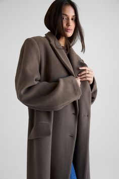 Elevate your wardrobe with the timeless Harper Maxi Wool Coat. This oversized silhouette is crafted with 100% soft wool detailed with double-breasted closures, chest welt pockets, front flap pockets, a back vent, side pockets, and elongated slouchy sleeves. Fully lined for maximum warmth. Timeless Winter Outerwear With Pockets, Timeless Fall Outerwear With Pockets, Elegant Oversized Wool Coat With Pockets, Classic Oversized Pea Coat With Pockets, Timeless Outerwear With Pockets For Fall, Oversized Business Pea Coat With Pockets, Classic Oversized Wool Coat For Fall, Oversized Classic Wool Coat For Fall, Classic Oversized Solid Pea Coat