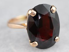 This ring features a simple and classically designed mounting, the structural openwork shoulders lend a sense of light and grace to the mounting. Cut into a classic oval cut, the deep red cherry garnet in the center adds a lovely pop of color and also an interesting shape to a simple ring!Metal: 14K Yellow GoldGem: Garnet 14.25 CaratsGem Measurements: 16.2 x 11.9 mm, OvalRing Size: 7.25 Simple Ring, Red Cherry, Ring Metal, Rings Simple, The Deep, Cocktail Ring, Cocktail Rings, Metal Rings, Deep Red