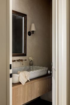 a bathroom sink sitting under a mirror next to a doorway