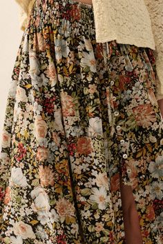 A floral woven maxi skirt with the following features: Smocked elastic waistband. Tie detail. High-waisted. Half button front closure. Front slit. Lined. Ankle length. Loose fit. 100% polyester Hand wash cold, line dry. Model Info: Height: 5 ft 9 in | Bust: 31 in | Waist: 24 in | Hips: 34 in | Wearing Size S. Goddess Attire, Flowy Floral Skirt, Nice Sandals, Mom Fashion, Closet Goals, Floral Maxi Skirt, Floral Print Skirt, Girls Sweet, Crop Top Sweater