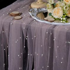 a table topped with a cake covered in frosting next to a vase filled with flowers