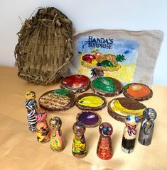 several small figurines are sitting on a table next to a basket and towel