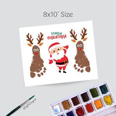 christmas card with santa claus and reindeers on it next to watercolor paint palette