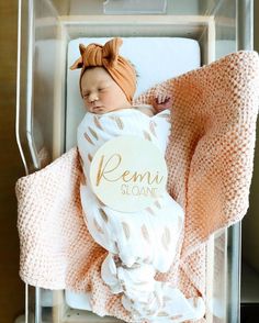 a newborn baby wrapped in a pink and white blanket with the name reni sloan on it