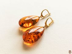 "Light orange natural amber earrings for women that love bright eye-catching colors. These drop shape genuine amber earrings brighten up your eyes. And we've heard - some lives too! Even though they are in cognac color, all they do is sweetens your life. MATERIALS AND SIZE: Stone: 100% Natural Baltic Amber Findings: Sterling silver 925 gold plated Earrings A: Weight: 7 g (0,324 oz) Bead size: 3 cm (1,18 in) x 1,6 cm (0,62 in) Total earring length:4,7 cm (1.85 in) Earrings B: Weight: 8,4 g (0,29o Elegant Baltic Amber Jewelry In Orange, Elegant Orange Baltic Amber Jewelry, Orange Baltic Amber Teardrop Jewelry, Baltic Amber Teardrop Earrings For Gift, Baltic Amber Teardrop Earrings As Gift, Amber Earrings For Gift, Baltic Amber Earrings As A Gift, Gift Amber Drop Earrings, Amber Teardrop Earrings As A Gift