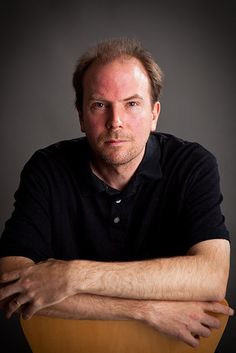 a man sitting in a chair with his arms crossed